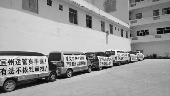 今年7月,宜州市运管局通过了当地另一家车检企业开展营运车辆综检业务的备案,引发原来“独家垄断”河池综检市场的企业的不满,其员工打出各种抗议标语。 资料图片